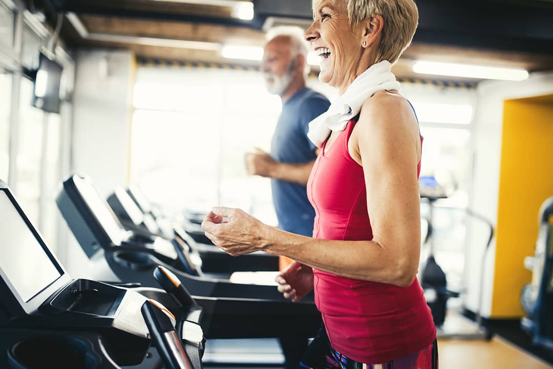Senior people using treadmill at a gym